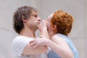 Un uomo e una donna vicini. Lui le tiene la mano sulla bocca