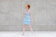 Una donna in piedi, guarda da un lato e ride