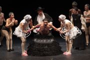 Foto di scena. Re Chicchinella tenuto da due ballerine vestite di bianco