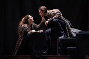 Foto di scena. Un uomo e una donna. La donna tiene la mano sulla bocca dell'uomo