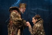 Foto di scena. Una donna tiene le mani di Re Lear
