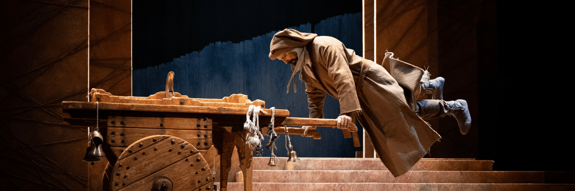 Foto di scena dove si vede Simone Cristicchi travestito da Francesco d'Assisi saltare su un carretto