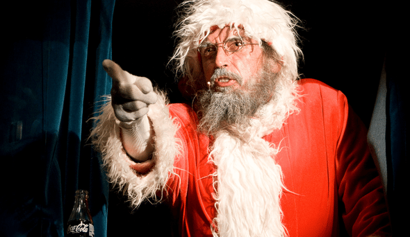 Attore vestito da Babbo Natale che punta il dito contro qualcuno